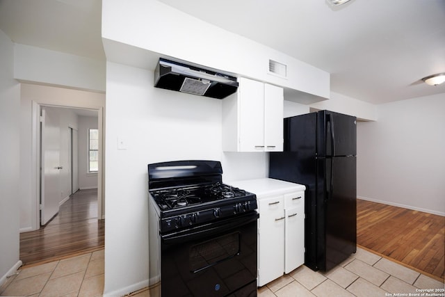 251 Serna, San Antonio, TX 78218 - kitchen featuring black appliances, light tile patterned floors, exhaust hood, and white cabinetry