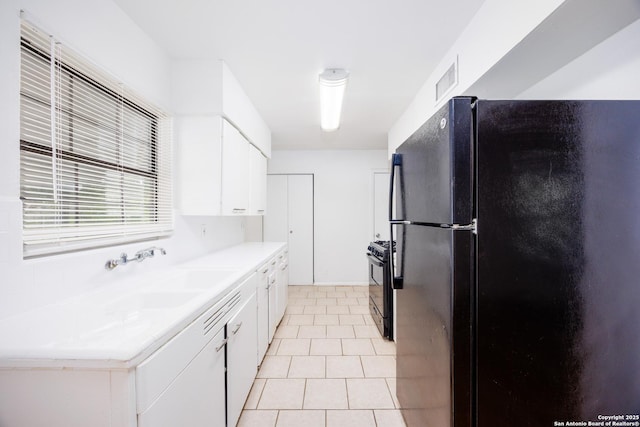251 Serna, San Antonio, TX 78218 - kitchen featuring black appliances, white cabinets, light countertops, and light tile patterned floors
