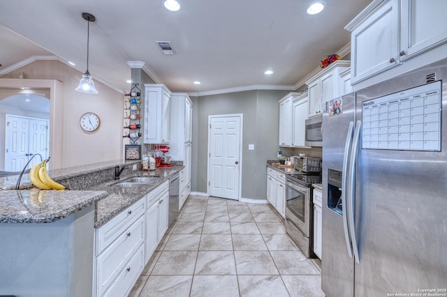 104 Sunday Ct, Uvalde, TX 78801 - kitchen featuring appliances with stainless steel finishes, a peninsula, white cabinetry, recessed lighting, and light stone counters