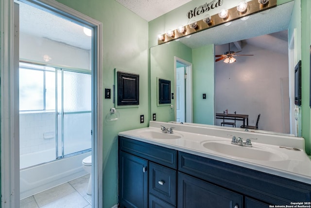 2500 Newning, Schertz, TX 78154 - bathroom featuring double vanity, ceiling fan, a textured ceiling, bath / shower combo with glass door, and tile patterned floors