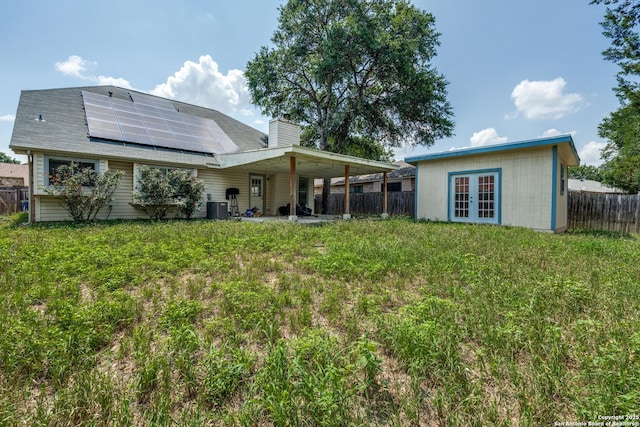 2500 Newning, Schertz, TX 78154 - back of property with french doors, roof mounted solar panels, a chimney, and a fenced backyard