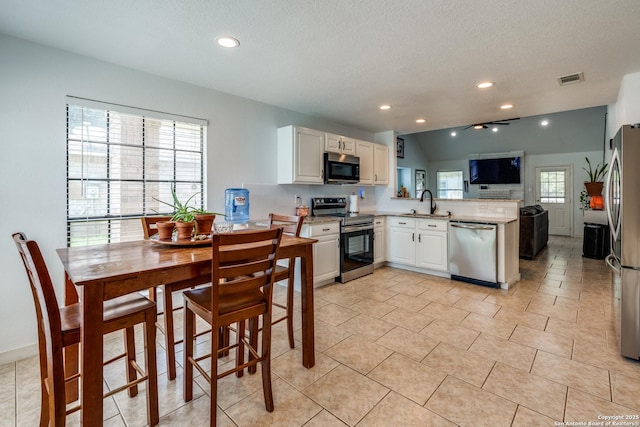 2500 Newning, Schertz, TX 78154 - kitchen with appliances with stainless steel finishes, a peninsula, white cabinets, open floor plan, and recessed lighting