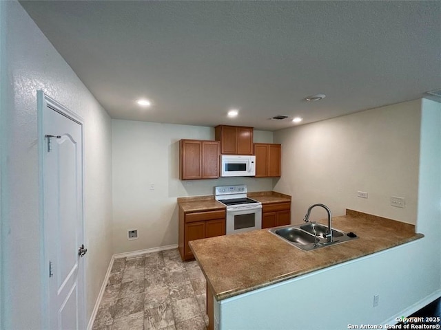 2092 Brandywine, New Braunfels, TX 78130 - kitchen with white appliances, a peninsula, brown cabinetry, and recessed lighting