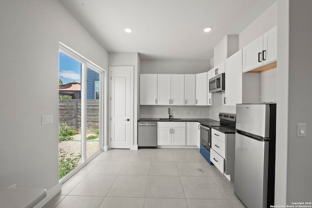 10706 Pharaoh Run, San Antonio, TX 78254 - kitchen featuring appliances with stainless steel finishes, dark countertops, white cabinets, light tile patterned flooring, and recessed lighting