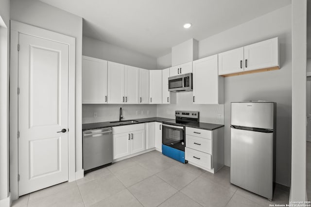 10706 Pharaoh Run, San Antonio, TX 78254 - kitchen with stainless steel appliances, dark countertops, white cabinetry, light tile patterned floors, and recessed lighting