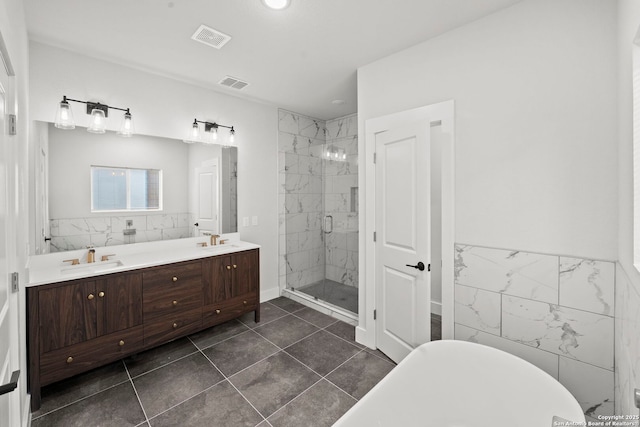 10706 Pharaoh Run, San Antonio, TX 78254 - bathroom featuring a stall shower, a freestanding tub, double vanity, tile walls, and wainscoting