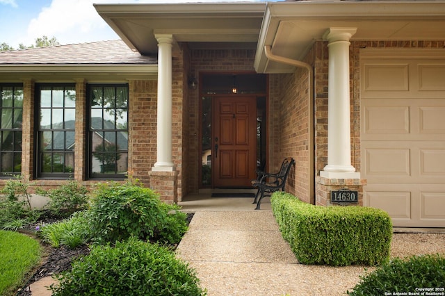 14630 Snip, San Antonio, TX 78248 - view of exterior entry featuring a garage, roof with shingles, and brick siding