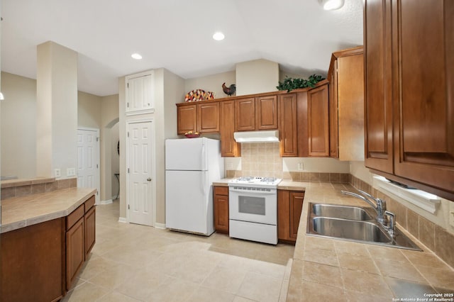 14630 Snip, San Antonio, TX 78248 - kitchen featuring white appliances, under cabinet range hood, brown cabinetry, backsplash, and vaulted ceiling