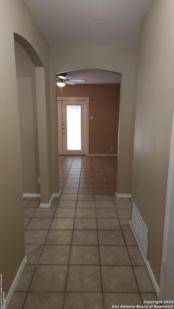 1826 Laven Dr, San Antonio, TX 78228 - hallway with arched walkways and light tile patterned floors