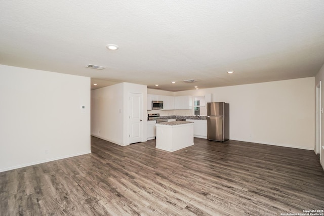 223 Baxter, Seguin, TX 78155 - unfurnished living room with dark wood-style floors and recessed lighting