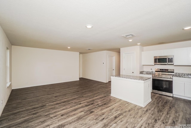 223 Baxter, Seguin, TX 78155 - kitchen featuring stainless steel appliances, dark wood finished floors, light stone countertops, a kitchen island, and open floor plan
