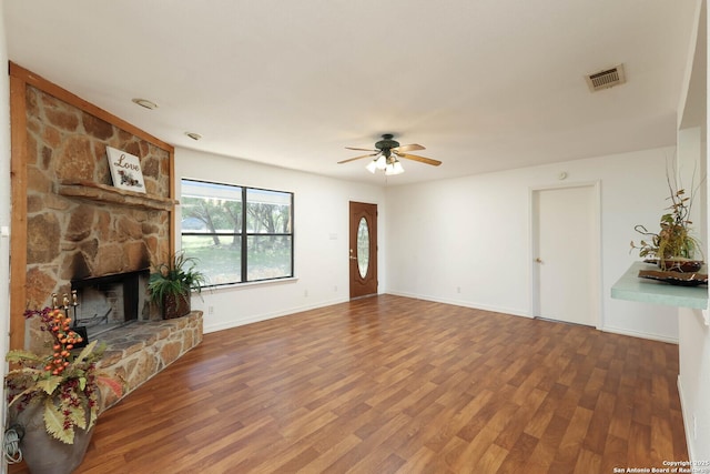 540 Soft Wind, Canyon Lake, TX 78133 - unfurnished living room featuring wood finished floors, a ceiling fan, and a stone fireplace
