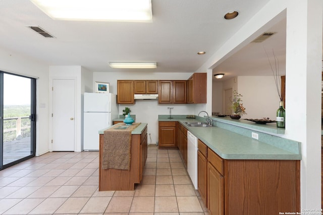 540 Soft Wind, Canyon Lake, TX 78133 - kitchen with white appliances, a center island, under cabinet range hood, brown cabinets, and light tile patterned flooring