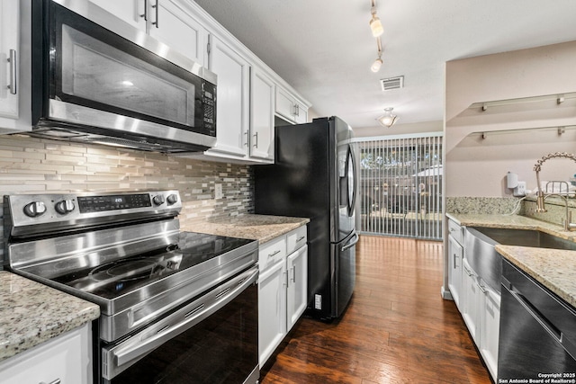 5811 Lake Chap, San Antonio, TX 78222 - kitchen featuring appliances with stainless steel finishes, decorative backsplash, white cabinetry, dark wood-style floors, and light stone countertops