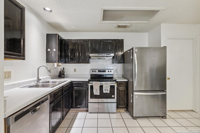 7643 Heathridge, San Antonio, TX 78250 - kitchen featuring appliances with stainless steel finishes, under cabinet range hood, light countertops, light tile patterned floors, and a textured ceiling