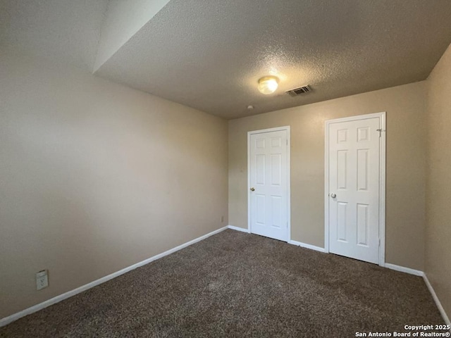 5103 Cabin Lake Dr, San Antonio, TX 78244 - unfurnished bedroom featuring a textured ceiling and dark colored carpet