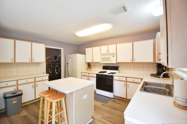 10310 Mission Crk, Converse, TX 78109 - kitchen with white appliances, washer and clothes dryer, backsplash, and light wood-type flooring