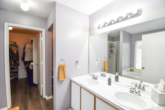 10310 Mission Crk, Converse, TX 78109 - full bathroom featuring a spacious closet, a bath, a shower stall, wood finished floors, and double vanity