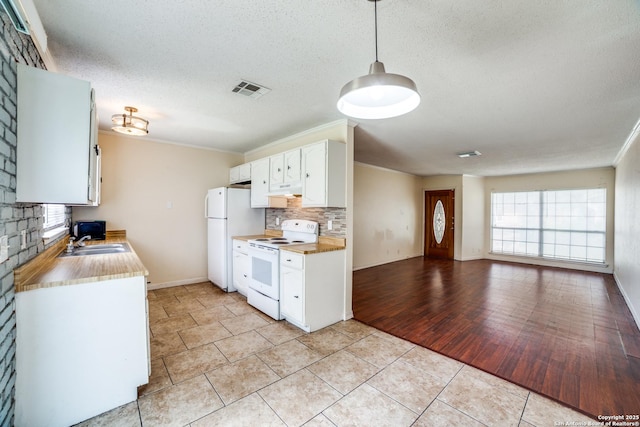 1034 Lemon Tree, San Antonio, TX 78245 - kitchen with white appliances, tasteful backsplash, white cabinets, a textured ceiling, and light tile patterned floors