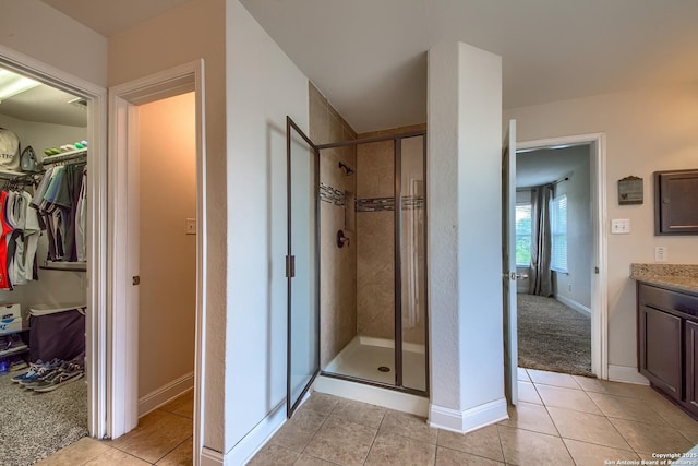 5938 Akin Song, San Antonio, TX 78261 - bathroom featuring a shower stall, tile patterned flooring, vanity, and a spacious closet