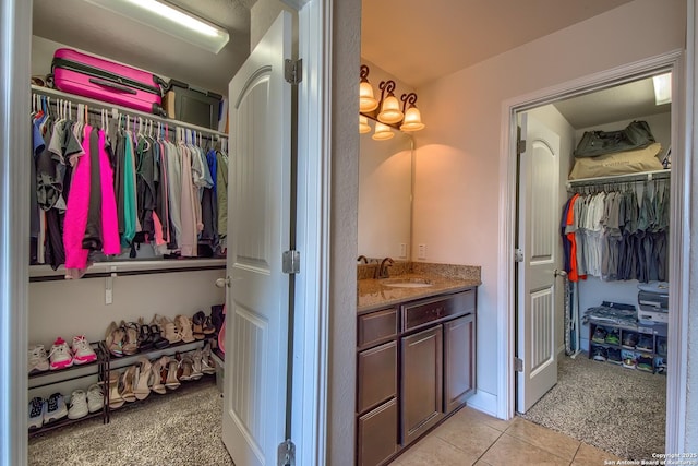 5938 Akin Song, San Antonio, TX 78261 - bathroom with vanity, a walk in closet, and tile patterned floors