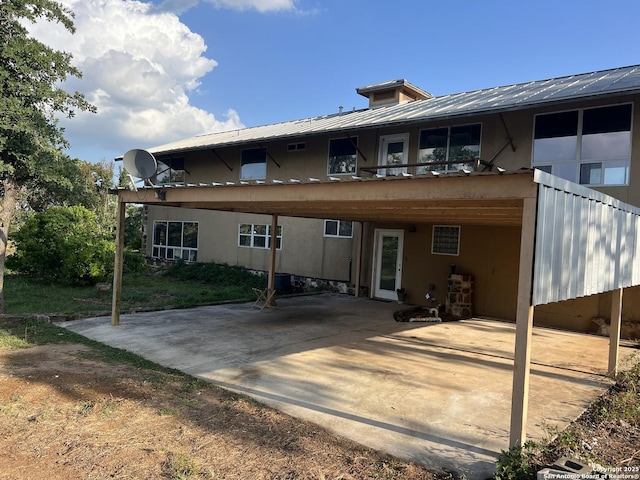 184 Guadalupe Hls, Seguin, TX 78155 - back of property featuring a metal roof, a patio area, a carport, and stucco siding
