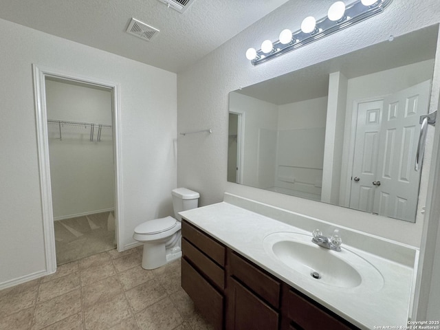 130 Palazzo Torre, San Antonio, TX 78253 - bathroom with vanity, a spacious closet, and a textured ceiling