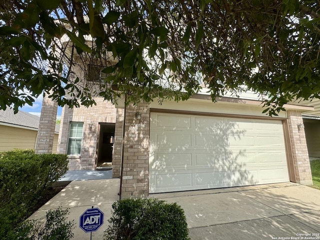 130 Palazzo Torre, San Antonio, TX 78253 - view of property hidden behind natural elements featuring concrete driveway, brick siding, and a garage
