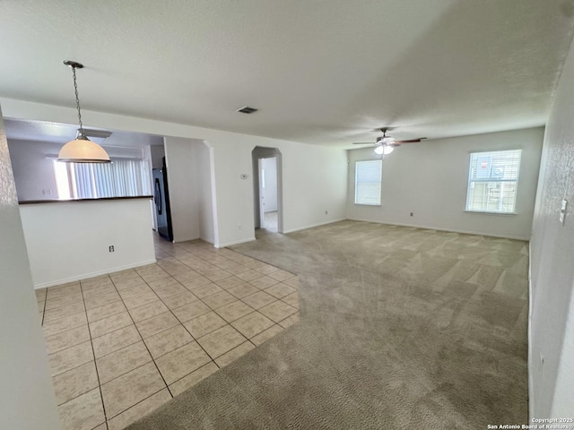 130 Palazzo Torre, San Antonio, TX 78253 - empty room with ceiling fan, arched walkways, light tile patterned flooring, and light carpet