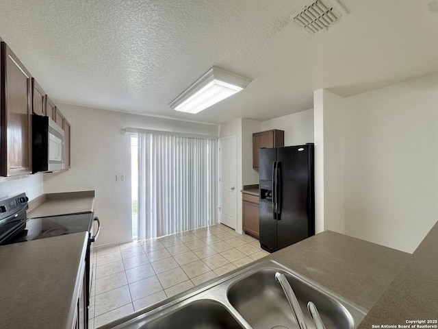 130 Palazzo Torre, San Antonio, TX 78253 - kitchen featuring black appliances, light tile patterned floors, and a textured ceiling