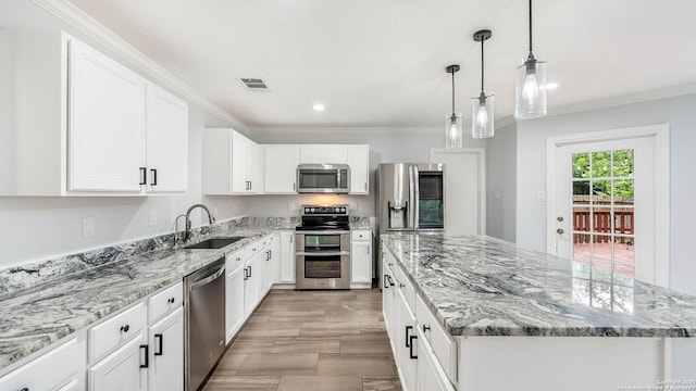 2530 Melrose Cyn, San Antonio, TX 78232 - kitchen with appliances with stainless steel finishes, a kitchen island, crown molding, light stone countertops, and white cabinetry
