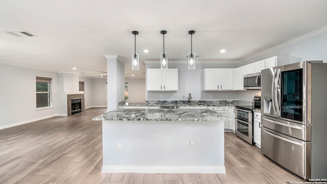 2530 Melrose Cyn, San Antonio, TX 78232 - kitchen with appliances with stainless steel finishes, ornamental molding, light stone counters, a kitchen island, and decorative light fixtures