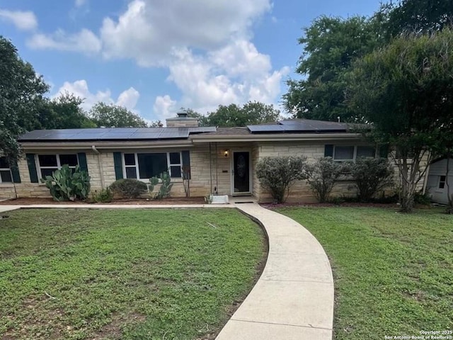 117 Bryker, Terrell Hills, TX 78209 - single story home with stone siding, a front lawn, roof mounted solar panels, and a chimney