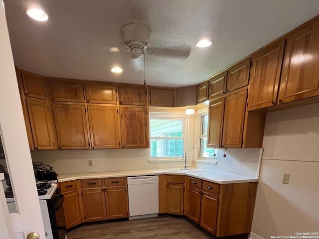 117 Bryker, Terrell Hills, TX 78209 - kitchen featuring white dishwasher, brown cabinetry, dark wood-type flooring, range with gas stovetop, and light countertops