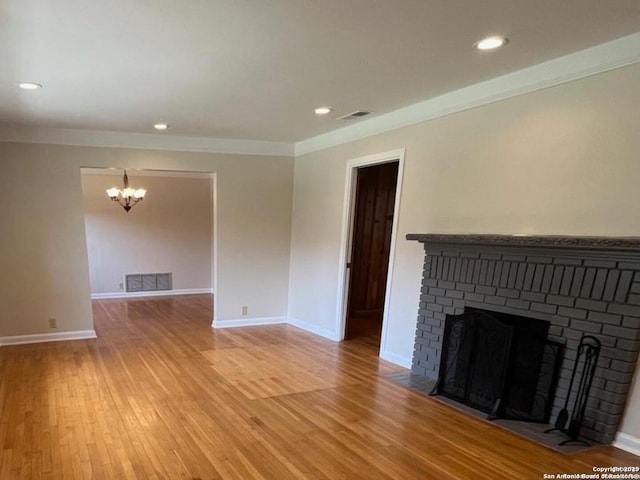 117 Bryker, Terrell Hills, TX 78209 - unfurnished living room with a chandelier, a brick fireplace, light wood-style floors, recessed lighting, and ornamental molding