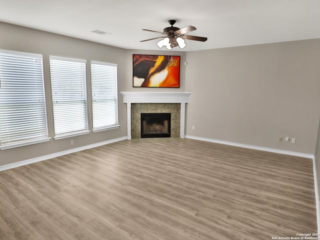 3610 Green Breeze, San Antonio, TX 78247 - unfurnished living room featuring light wood-type flooring, ceiling fan, and a tiled fireplace