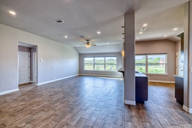 13 Hope, Uvalde, TX 78801 - unfurnished living room with dark wood-style floors, ceiling fan, lofted ceiling, and recessed lighting