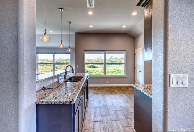 13 Hope, Uvalde, TX 78801 - kitchen featuring recessed lighting, wood finished floors, a textured wall, light stone counters, and decorative light fixtures