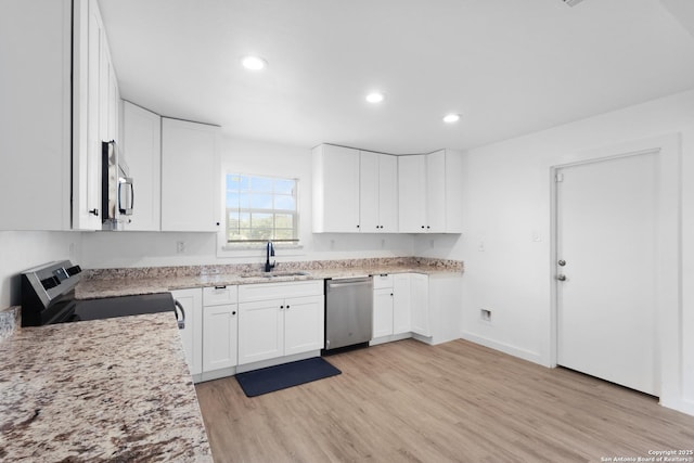 502 E Palfrey, San Antonio, TX 78223 - kitchen with appliances with stainless steel finishes, light wood-style flooring, light stone countertops, recessed lighting, and white cabinetry