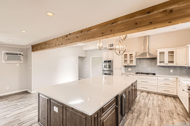 142 Winn, Universal City, TX 78148 - kitchen with wall chimney exhaust hood, a wall mounted air conditioner, double oven, white cabinets, and recessed lighting
