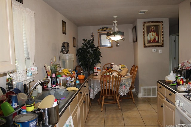 401 W Lindbergh Blvd, Universal City, TX 78148 - kitchen featuring light tile patterned floors, dark countertops, water heater, and white gas stove