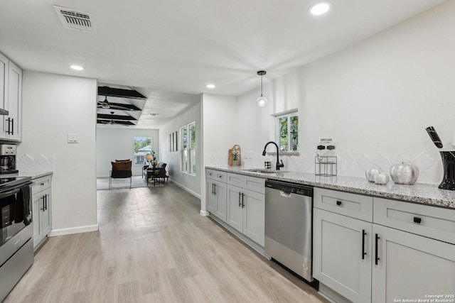 333 S Mesquite, New Braunfels, TX 78130 - kitchen featuring stainless steel appliances, recessed lighting, light wood finished floors, healthy amount of natural light, and light stone countertops