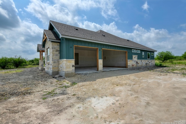 133 Wild Persimmon Trl, Marion, TX 78124 - view of home's exterior featuring board and batten siding, stone siding, roof with shingles, and dirt driveway