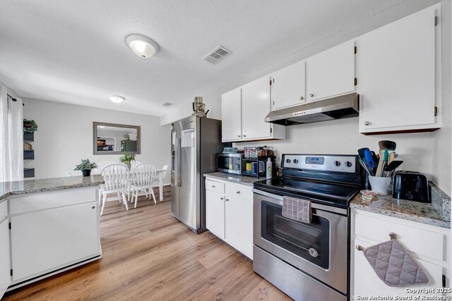 808 Fern Mdw, Universal City, TX 78148 - kitchen featuring stainless steel appliances, under cabinet range hood, white cabinets, light wood-type flooring, and light stone countertops