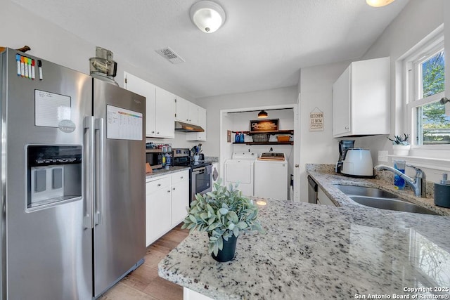 808 Fern Mdw, Universal City, TX 78148 - kitchen with appliances with stainless steel finishes, independent washer and dryer, white cabinetry, and light stone countertops