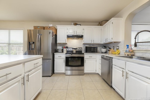 11862 Barkston, San Antonio, TX 78253 - kitchen featuring appliances with stainless steel finishes, healthy amount of natural light, light tile patterned floors, and backsplash