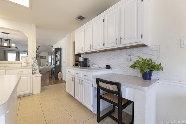 11862 Barkston, San Antonio, TX 78253 - kitchen featuring decorative backsplash, light countertops, white cabinetry, light tile patterned floors, and lofted ceiling