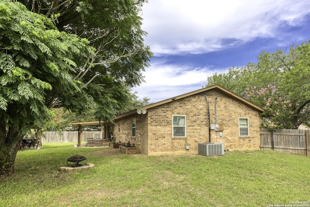 1245 Whitney, Pleasanton, TX 78064 - rear view of house with a fire pit, brick siding, and a fenced backyard