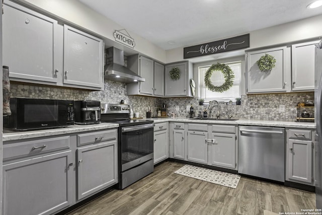 1245 Whitney, Pleasanton, TX 78064 - kitchen with appliances with stainless steel finishes, wall chimney exhaust hood, gray cabinets, decorative backsplash, and recessed lighting