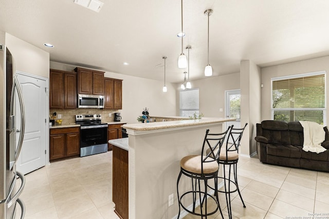 435 Red Quill Nest, San Antonio, TX 78253 - kitchen featuring appliances with stainless steel finishes, light tile patterned floors, decorative backsplash, a breakfast bar, and light countertops